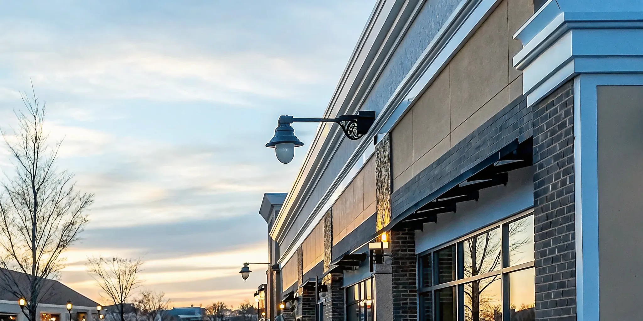 Illuminated channel letter sign installation on a brick storefront facade at a Long Island shopping plaza